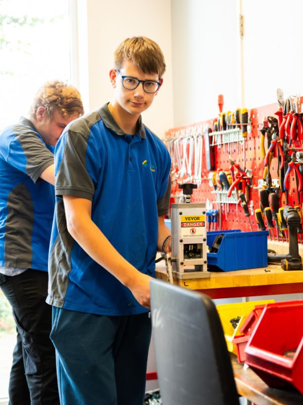 Leerlingen aan het werk in de werkplaats van Talryk Twee jongens aan het werk in de werkplaats