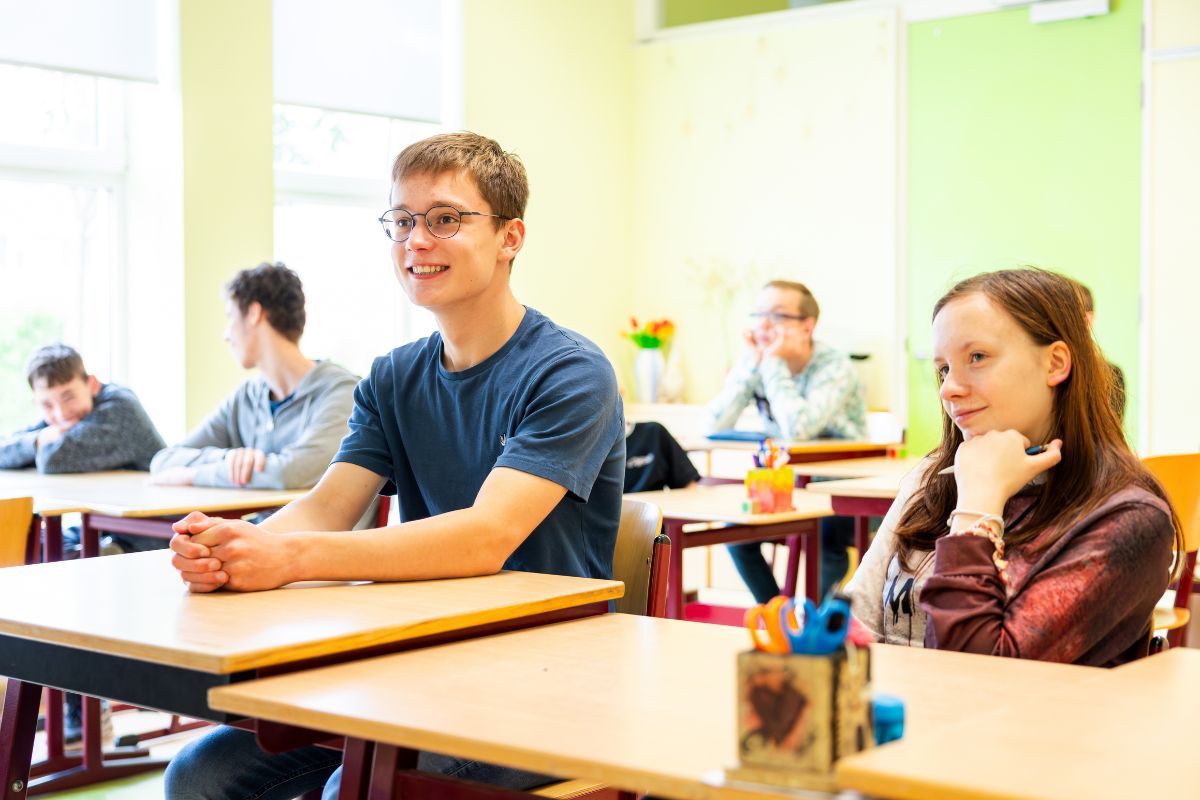 Aandachtig leren in de klas Leerlingen zitten aan hun tafel en luisteren tijdens een lesmoment in het klaslokaal