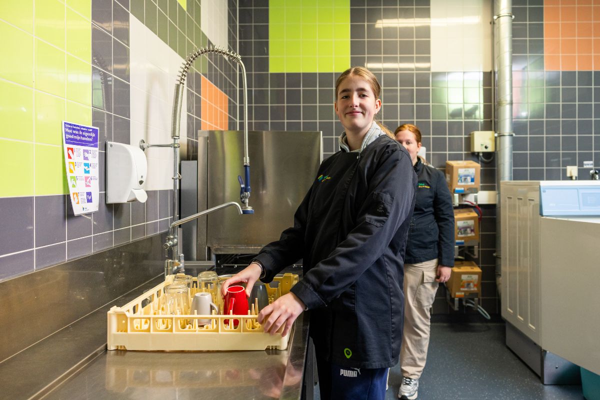 Werkervaring in de keuken eerling voert een taak uit in een professionele keuken tijdens een praktijkmoment