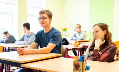 Twee leerlingen werken samen aan een opdracht met een projector in een klaslokaal van Talryk.