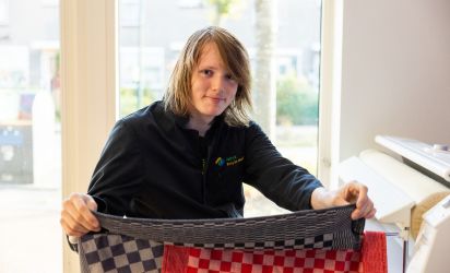 Praktische vaardigheden ontwikkelen Leerling van Talryk oefent met textiel en ontwikkelt praktische vaardigheden tijdens een praktijkles.