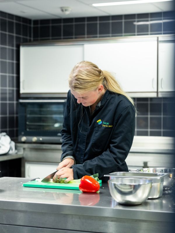 leerling van Talryk is groente aan het snijden Meisje is groente aan het snijden in de kantine
